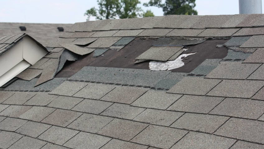 Damaged shingles on residential roof.